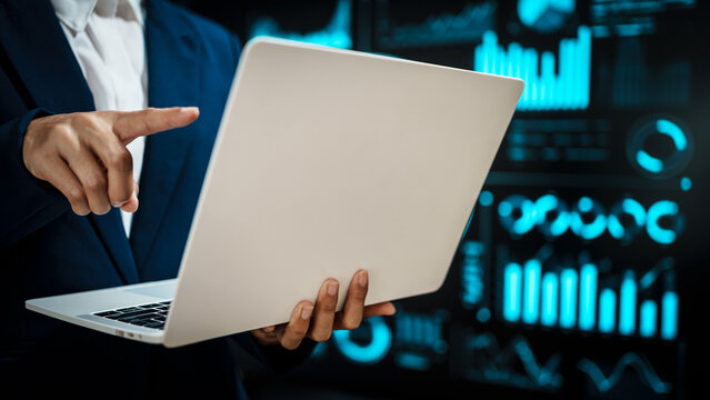 Professional working on laptop in front of futuristic digital dashboards, highlighting data analytics, cybersecurity insights, real-time visual information that reflect modern technology. - Powered by Adobe