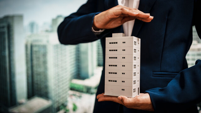 Business woman presenting miniature building model city skyline, real estate assets, property development,land rights,long-term investment, rental income, stable value growth of immovable properties.