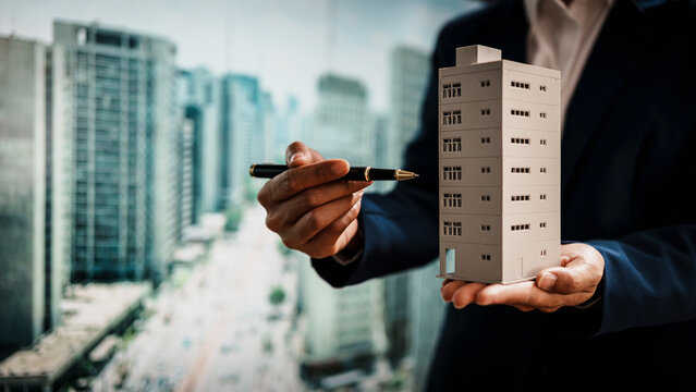 Business woman presenting miniature building model city skyline, real estate assets, property development,land rights,long-term investment, rental income, stable value growth of immovable properties.
