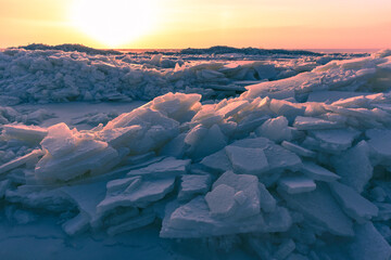 A dramatic winter scene shows broken ice chunks piled along a frozen sea