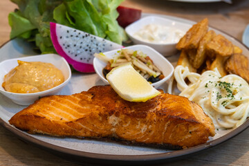 Sizzling salmon served with sides a cozy restaurant dining experience with aesthetic flair