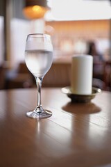 Empty wine glass on wooden table with candle and soft bokeh mood in intimate lighting