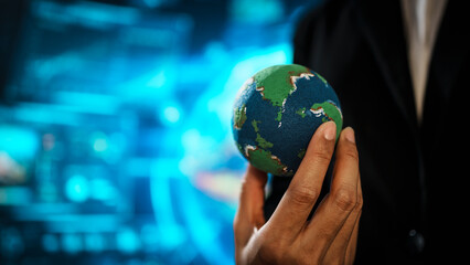 Business professional holding small Earth model before futuristic digital interface, global responsibility,environmental awareness,world protection, sustainability, modern international collaboration