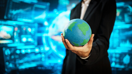 Business professional holding small Earth model before futuristic digital interface, global responsibility,environmental awareness,world protection, sustainability, modern international collaboration