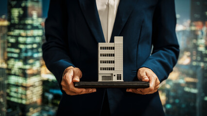 Businesswoman presents modern building model against a vibrant cityscape, real estate investment, property development, strategic planning, corporate decision-making in the commercial property sector