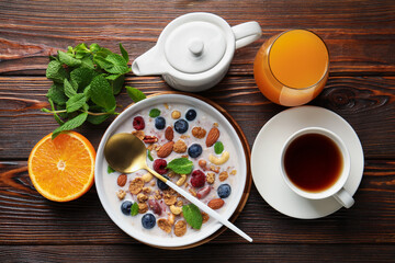 Healthy breakfast. Oatmeal with nuts, berries and milk in bowl served on wooden table, flat lay
