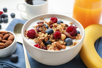 Healthy breakfast. Oatmeal with nuts, berries and milk on white wooden table, closeup