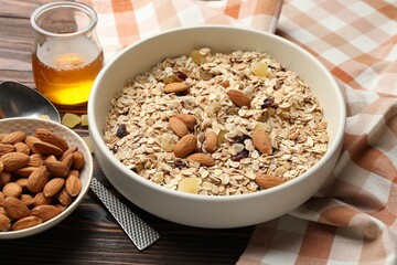 Making granola. Oat flakes, dried fruits, almond nuts and honey on wooden table, closeup