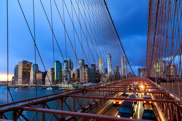 Obraz premium Brooklyn Bridge connects Manhattan Brooklyn with NY city lights traffic at dusk