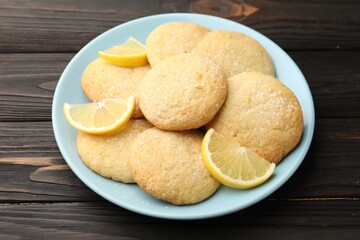 Tasty lemon cookies and fruit slices on black wooden table, closeup