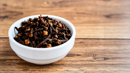 Dry Clove Spices in Ceramic Bowl on Wooden Table for Premium Spice Object and Herbal Culinary Ingredient Concept