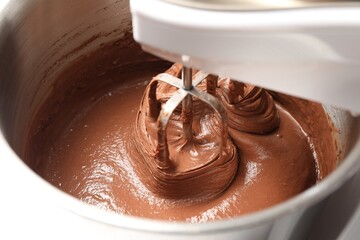 Mixing chocolate dough in bowl, closeup view