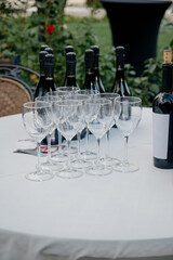 Table setting for a wine party with bottles and empty drink glasses