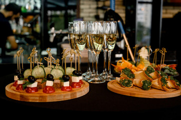 Buffet table with canapes and champagne in tall glasses in a restaurant