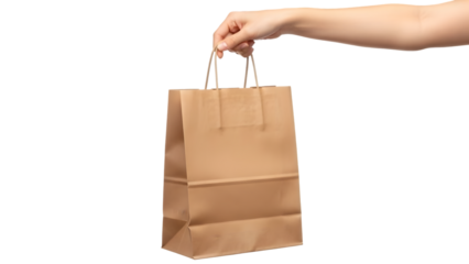 Hand holding a brown paper shopping bag against a dark isolated background