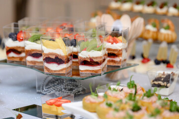 Banquet table setting with red apple, chocolate dessert and glass goblets