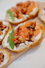 Close-up of bruschetta with sliced tomatoes, cream cheese, arugula