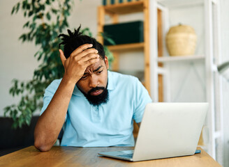 Portrait of a young man with laptop at home