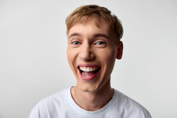 Smiling young man with a wide cheerful grin, close up shot capturing positive emotion, friendly energy and approachable vibe for lifestyle, happiness, and upbeat messaging in advertising and