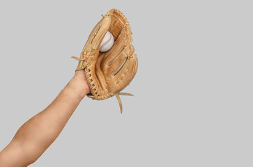 Raised arm holding baseball glove catching ball on neutral background, isolated sports concept.