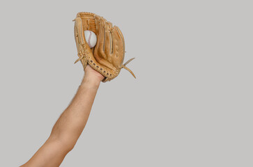 Raised arm holding baseball glove with captured ball symbolizes victory, triumph, and moment success