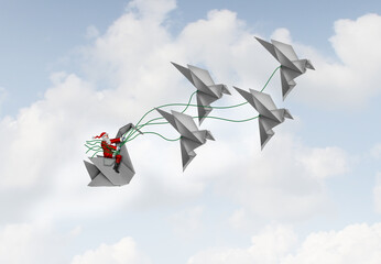 Creative Seasonal Celebration as santaclause with origami flying birds and a swan as a sleigh representingcreativity and imagination as aNew Year and  Christmas celebration.