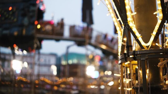 Glowing Christmas Garlands Light Up The Amusement Park At Night With A Blurred Colorful Kids Roller Coaster Train In The Background