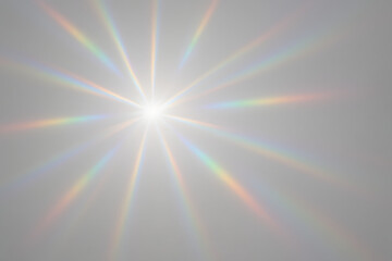 Fototapeta premium Sunlight Dispersion: The bright sun radiating out beams of rainbow light across the light-grey background, this image captures the beauty of light and the spectacle it creates.