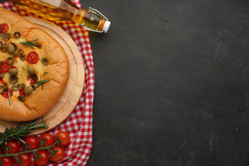 Focaccia alle olive - baked sandwich with green olives and rosemary on wooden background