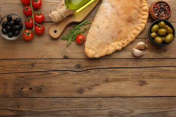 Pizza calzone with basil leaves close up with restaurant background. classic italian food