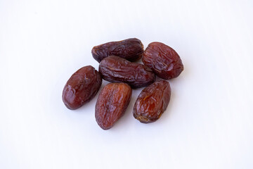 Close-up of fresh, delicious Medjool Dates fruit (Phoenix dactylifera) isolated on a white background. Healthy snack, sweet food, energy boost, and Ramadan concepts.