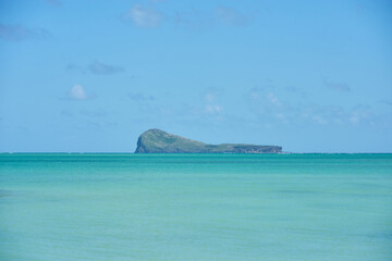 A scenic view of Coin de Mire Island off the northern coast of Mauritius, showcasing its dramatic volcanic cliffs surrounded by deep blue ocean waters, a striking landmark of the island&rsquo;s beauty