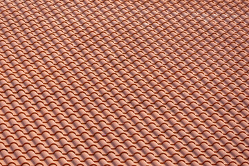 Seamless background texture of classic terracotta roof tiles made of natural clay. Detailed pattern of overlapping tiles, perfect for construction, architecture, and design themes.