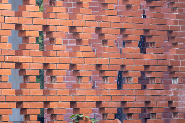 Architectural background texture: A modern, openwork brick screen wall (Jali or perforated brick wall) design used in contemporary buildings for aesthetic shadow patterns and airflow.