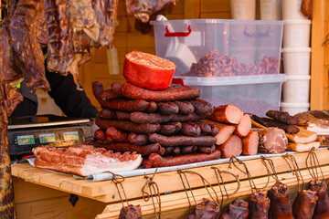 A variety of smoked and cured meat products at a market. 