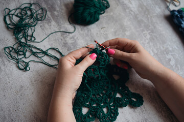 first-person view of hands of crocheting woman
