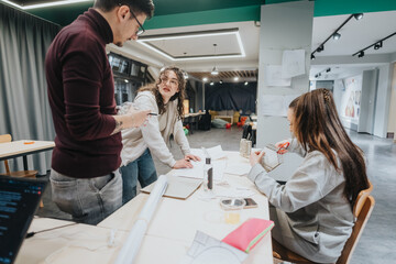 A group of students in a bright collaboration center work on hands-on design projects, crafting geometric models, sharing ideas, and helping each other during a creative workshop.