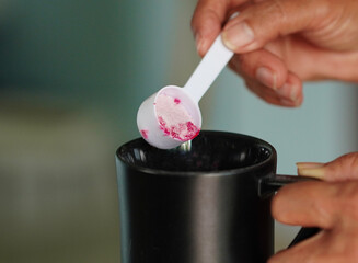Lifestyle Health care. Hand person scooping collagen powder. Collagen, which contains vitamins, helps nourish, anti age, nutrition and restore the body's deterioration. Healthy snacks morning routine 