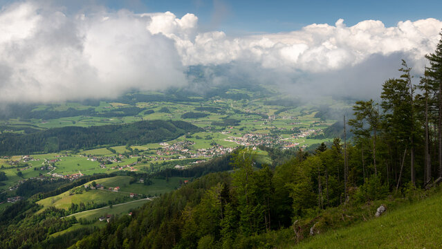 Sunny valley view with clouds above mountain horizon