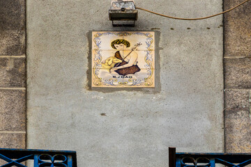 Decorative religious azulejo tile depicting Saint John on an old stone wall, Portugal, Porto, 11 October 2025