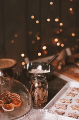 Holiday gingerbread men baking cookies, festive kitchen atmosphere with bokeh lights and ingredients for Christmas treats