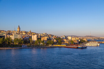 Panoramic view from Halic Bridge featuring the Galata Tower, Karaköy waterfront with ferries, and the distant Bosphorus. Istanbul, Turkey