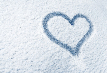 Heart is painted on the glass of the car, on the background of snow. Symbol of love, romance, Valentine's Day
