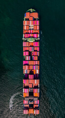 A container ship, fully loaded with goods, sails out to sea, delivering products to various locations around the world.