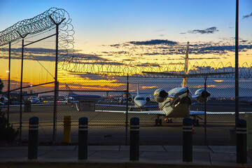 Las Vegas Airport Sunrise Private Airplane and Security Fence Golden Hour