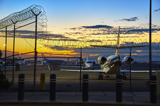 Fototapeta Las Vegas Airport Sunrise Private Airplane and Security Fence Golden Hour