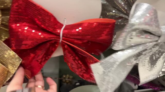 Sparkling red gold and silver sequin bows on the shelf in the store for a festive celebration.