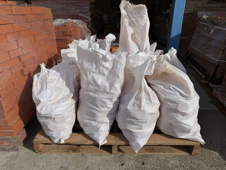 White sacks of construction material on a wooden pallet