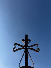 Ornate Wrought Iron Cross Silhouette Against Clear Blue Sky, Low Angle View