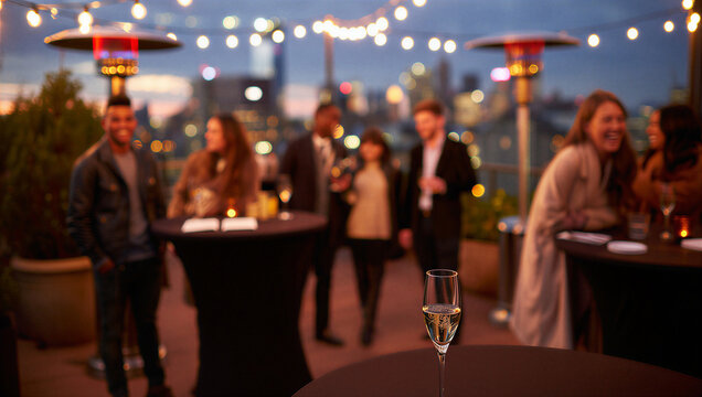 Urban Rooftop Social Event: Evening Gathering with Friends, Patio Heaters, String Lights, City Views